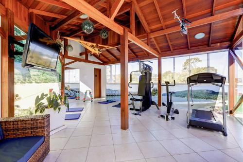 a gym with treadmills and a flat screen tv at Village Paraíso in Florianópolis