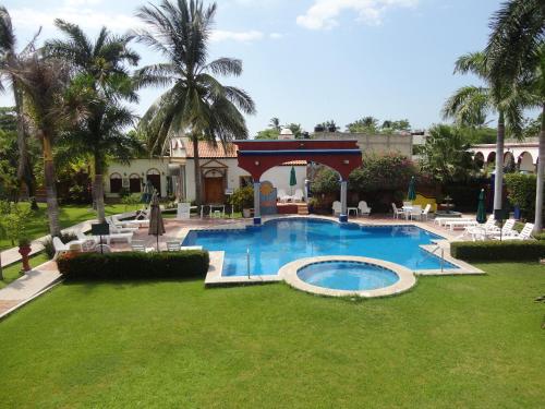 a swimming pool with a gazebo in a yard at Hotel Hacienda Flamingos in San Blas