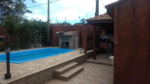 a swimming pool with a fireplace in a backyard at Pousada Boracéia 1 - Bertioga in Boracéia