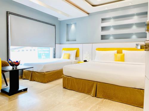 two beds in a hotel room with a window at City Empire New Delhi Train Station in New Delhi