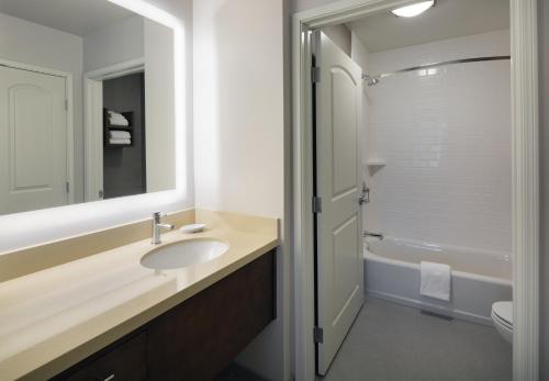 a bathroom with a sink and a toilet and a mirror at Staybridge Suites - Phoenix – Biltmore Area by IHG in Phoenix