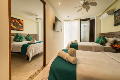 una camera d'albergo con due letti e uno specchio di Hotel Boutique Marbore a Santa Marta