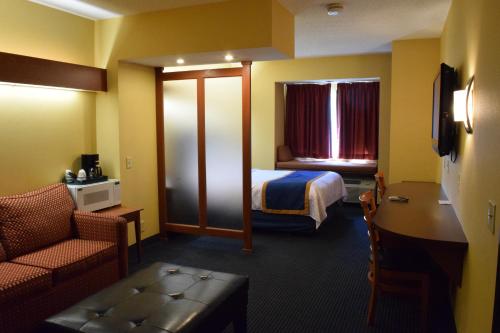 a hotel room with a bed and a chair at Inn at the Finger Lakes in Auburn