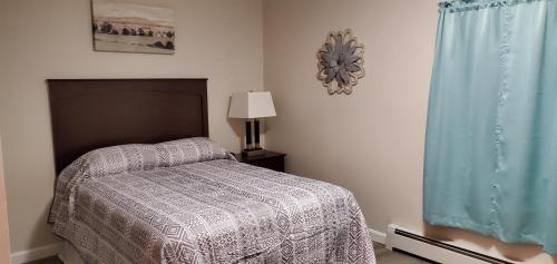 um quarto com uma cama, um candeeiro e uma janela em King Phillip motel em Gardner