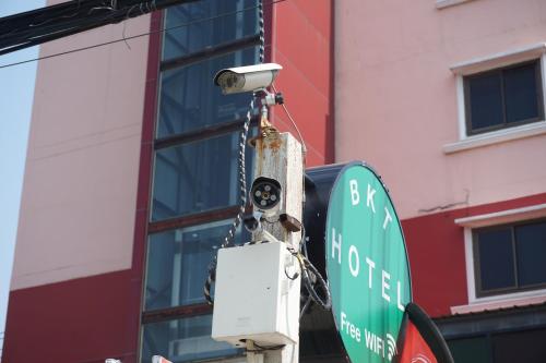 a street light and a street sign next to a building at Bangkok Travel Suites Hotel in Nonthaburi