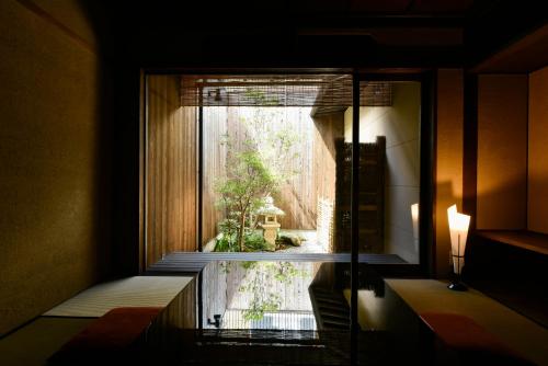 Habitación con vistas al jardín desde la ventana. en Rinn Premium Machiya Yae, en Kioto