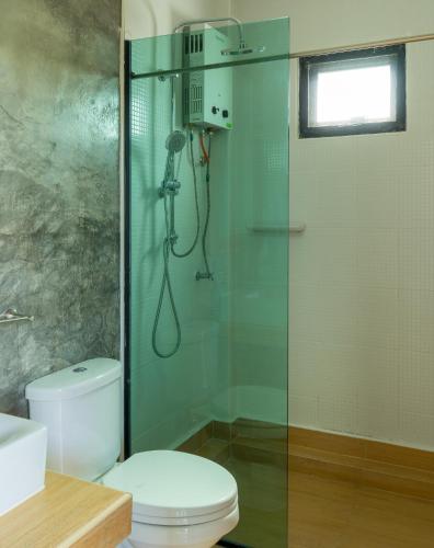a bathroom with a shower with a toilet and a glass door at Baan Phu Pa Pha บ้านภูปภา in Ban Sap Bon
