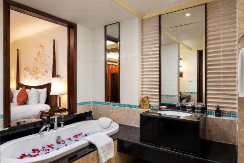 La salle de bains est pourvue d'une baignoire, de 2 lavabos et d'un lit. dans l'établissement Patong Paragon Resort & Spa SHA Extra Plus, à Patong Beach