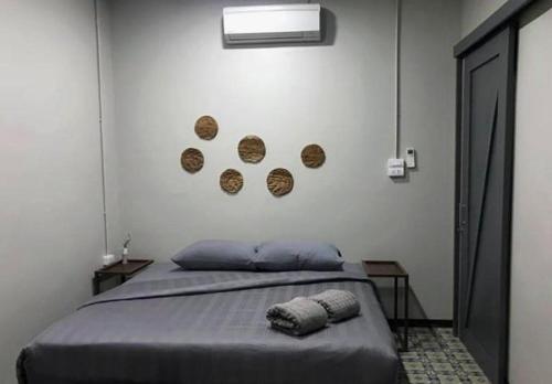 a bedroom with a bed with plates on the wall at Chato Hostel in Pakse