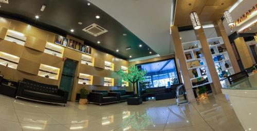a lobby of a building with couches and a tv at Paragon Lutong Hotel in Lutong