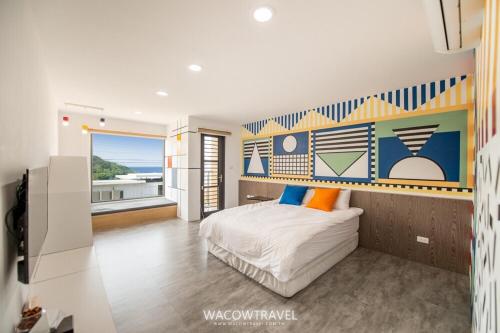 a bedroom with a bed with a mural on the wall at Twenty Eight B&B in Xiaoliuqiu
