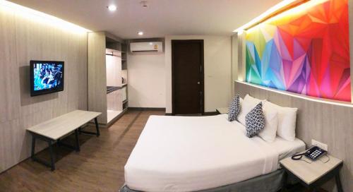 a hotel room with a bed and a tv at The Mini R Ratchada in Bangkok