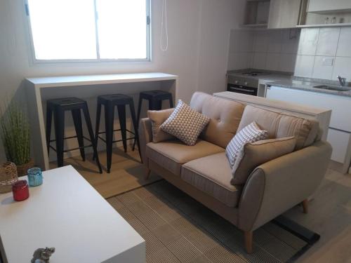 uma sala de estar com um sofá e uma cozinha em Departamento centrico Alvear em Paraná