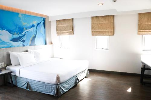 a bedroom with a bed and two windows at The Mini R Ratchada in Bangkok