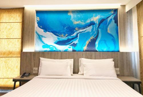 曼谷的住宿－叻差達迷你R酒店，一间卧室,上方有一张画作