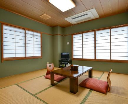 赤穂市にあるHotel Yamachouのテーブルと椅子と窓のあるリビングルーム