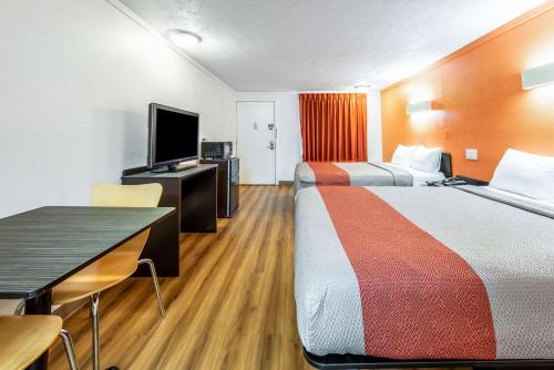 a hotel room with two beds and a desk and a tv at Motel 6-Mansfield, OH in Mansfield