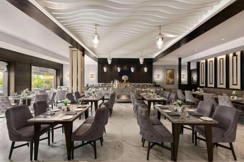 a restaurant with tables and chairs in a room at Ramada by Wyndham Kapurthala in Kapūrthala