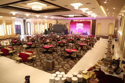a banquet hall with tables and chairs in a building at Ramada by Wyndham Kapurthala in Kapūrthala