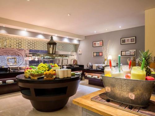 a kitchen with a buffet of fruit on a table at Novotel Deira Creekside Dubai in Dubai