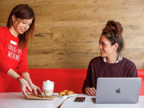 two women sitting at a table with a laptop at ibis Brighton City Centre - Station in Brighton & Hove