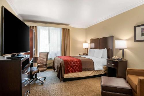 a hotel room with a bed and a flat screen tv at Comfort Inn Columbia Gorge in The Dalles