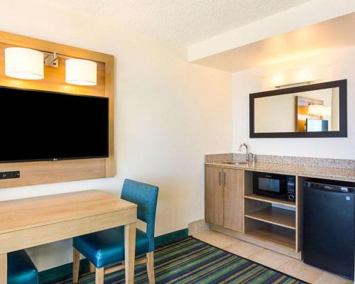 a hotel room with a desk and a sink at Comfort Suites Beachfront in Virginia Beach