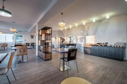 - une grande cuisine avec une table et des chaises dans l'établissement Comfort Hotel Linas - Montlhery, à Montlhéry