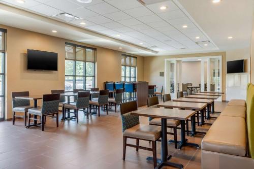 a dining room with tables and chairs and a flat screen tv at Comfort Inn & Suites Florence Center Area in Florence
