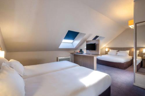 Cette chambre comprend 2 lits et une télévision. dans l'établissement Comfort Hotel Linas - Montlhery, à Montlhéry