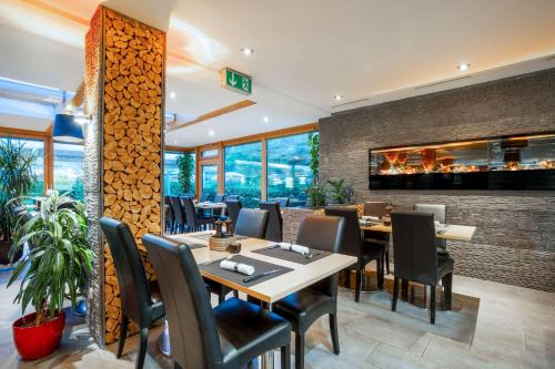 a restaurant with tables and chairs and a fireplace at MEAT UND STAY Hotel in Haar