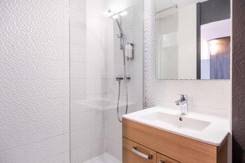 a white bathroom with a sink and a shower at Best Western Hôtel Agen Le Passage, Agen Sud in Le Passage