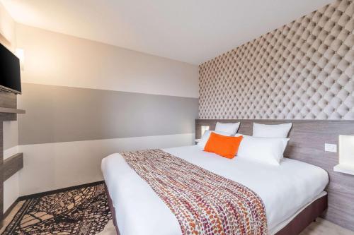 a bedroom with a large bed with an orange pillow at Best Western Hôtel Agen Le Passage, Agen Sud in Le Passage