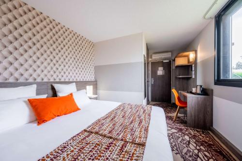 a hotel room with a large bed and a window at Best Western H&ocirc;tel Agen Le Passage, Agen Sud in Le Passage