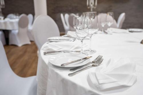 a white table with glasses and silverware on it at MEAT UND STAY Hotel in Haar