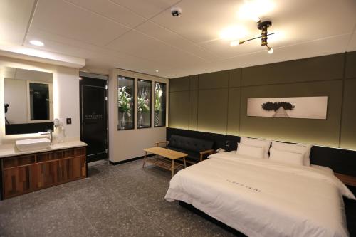 a bedroom with a large bed and a sink at Idea Hotel in Pohang