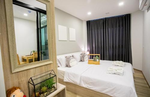 una camera con due letti e uno specchio di casa coco residence a Nakhon Ratchasima