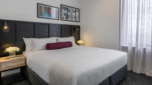 a bedroom with a large white bed and a window at Avani Melbourne Box Hill Residences in Box Hill