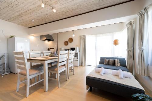 a kitchen and dining room with a table and chairs at Little Santa in Ginowan