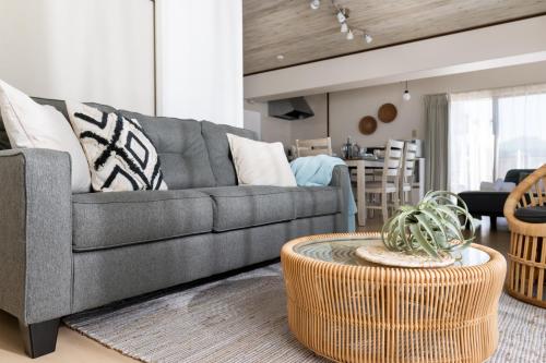 a living room with a gray couch and a table at Little Santa in Ginowan