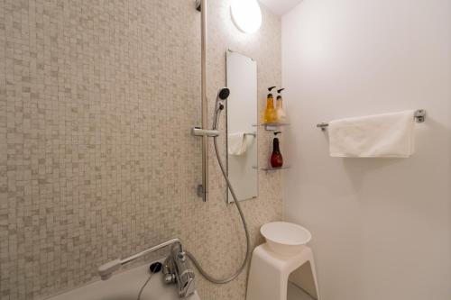 a bathroom with a shower with a toilet and a sink at Little Santa in Ginowan