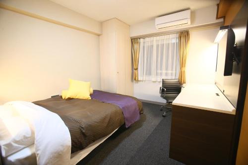 um quarto de hotel com uma cama e uma secretária em Hotel 1-2-3 Maebashi Mercury em Maebashi