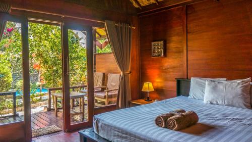 a bedroom with a bed with two towels on it at Giliranta in Gili Trawangan
