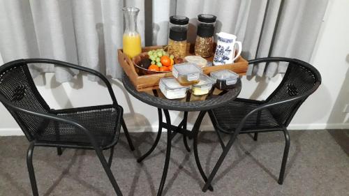 a table with a tray of food and two chairs at Kaimai Sunset Bed & Breakfast in Matamata