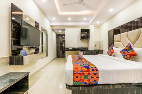 a bedroom with a large bed and a flat screen tv at FabHotel Crown Heights - Nr Koramangala Club in Bengaluru
