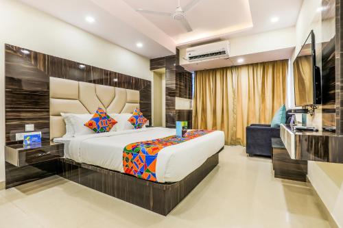 a bedroom with a large bed and a television at FabHotel Crown Heights - Nr Koramangala Club in Bengaluru