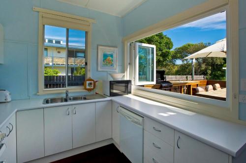 a kitchen with a sink and a large window at Blue River Shack in Wooli