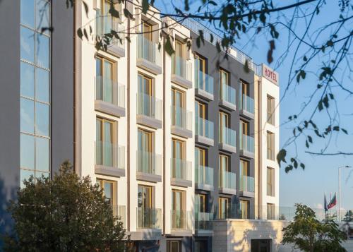 a large white building with windows at Amiral Hotel (former Best Western Park Hotel) in Varna City