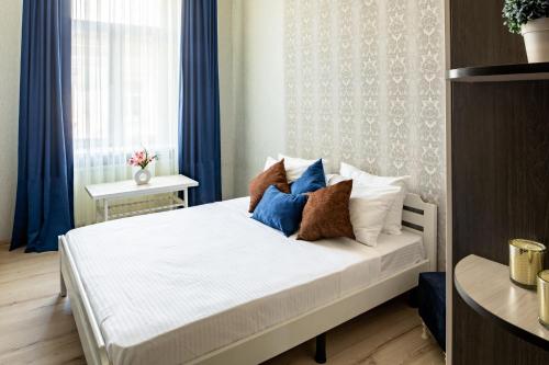 - une chambre avec un lit blanc avec des oreillers et une fenêtre dans l'établissement Alfa Apartments Kniazia Romana 11, à Lviv