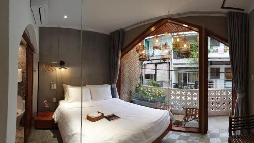 a bedroom with a large bed and a large window at Saigon1984 Vintage Private Home Central District 1 with 6 bedrooms and 6 bathrooms in Ho Chi Minh City
